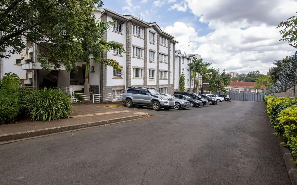 Multi-car parking bay with modern residential building facade
