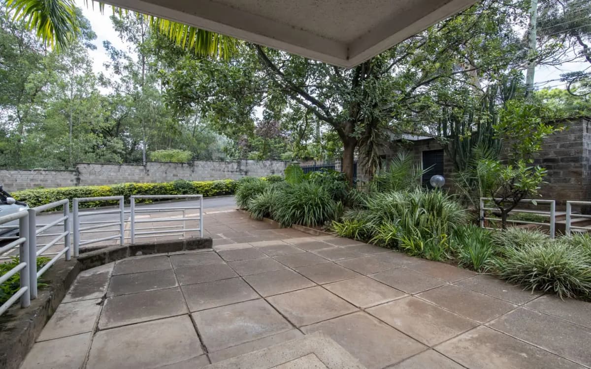 Covered terrace with paved flooring overlooking lush gardens