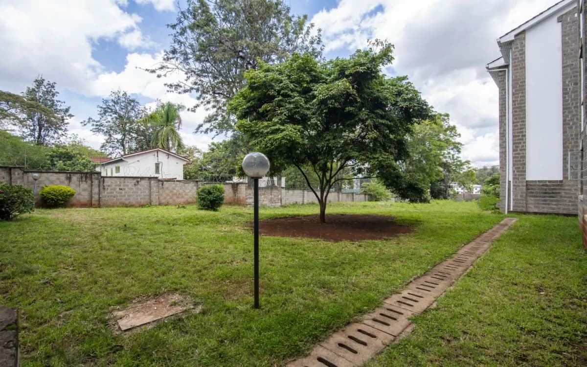 Spacious compound grounds with manicured lawn and mature trees