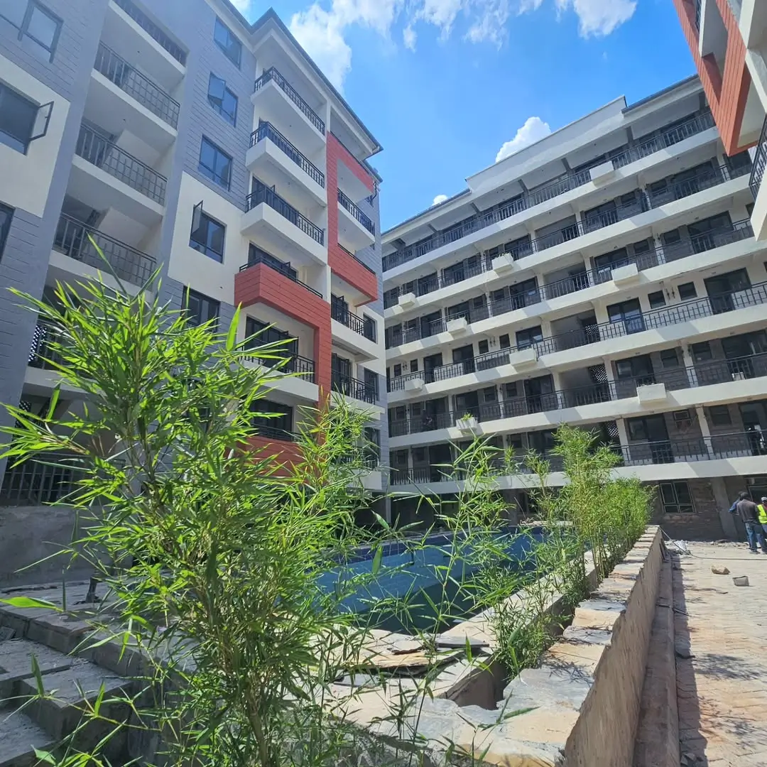 Multi-story residential complex with landscaped courtyard and green plants