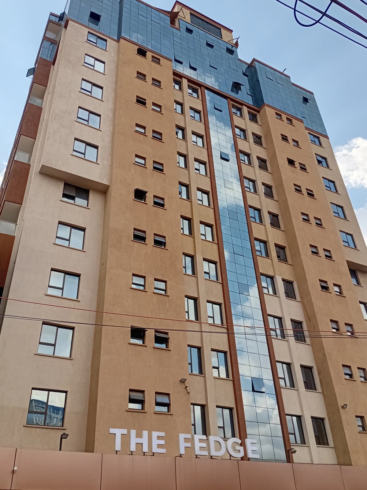 Multi-story residential building facade with mixed finishes