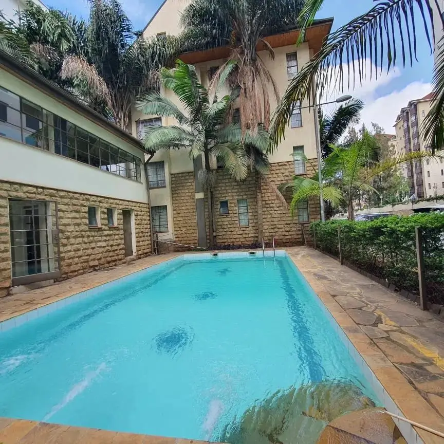 Rectangular swimming pool with tropical landscaping and terracotta decking