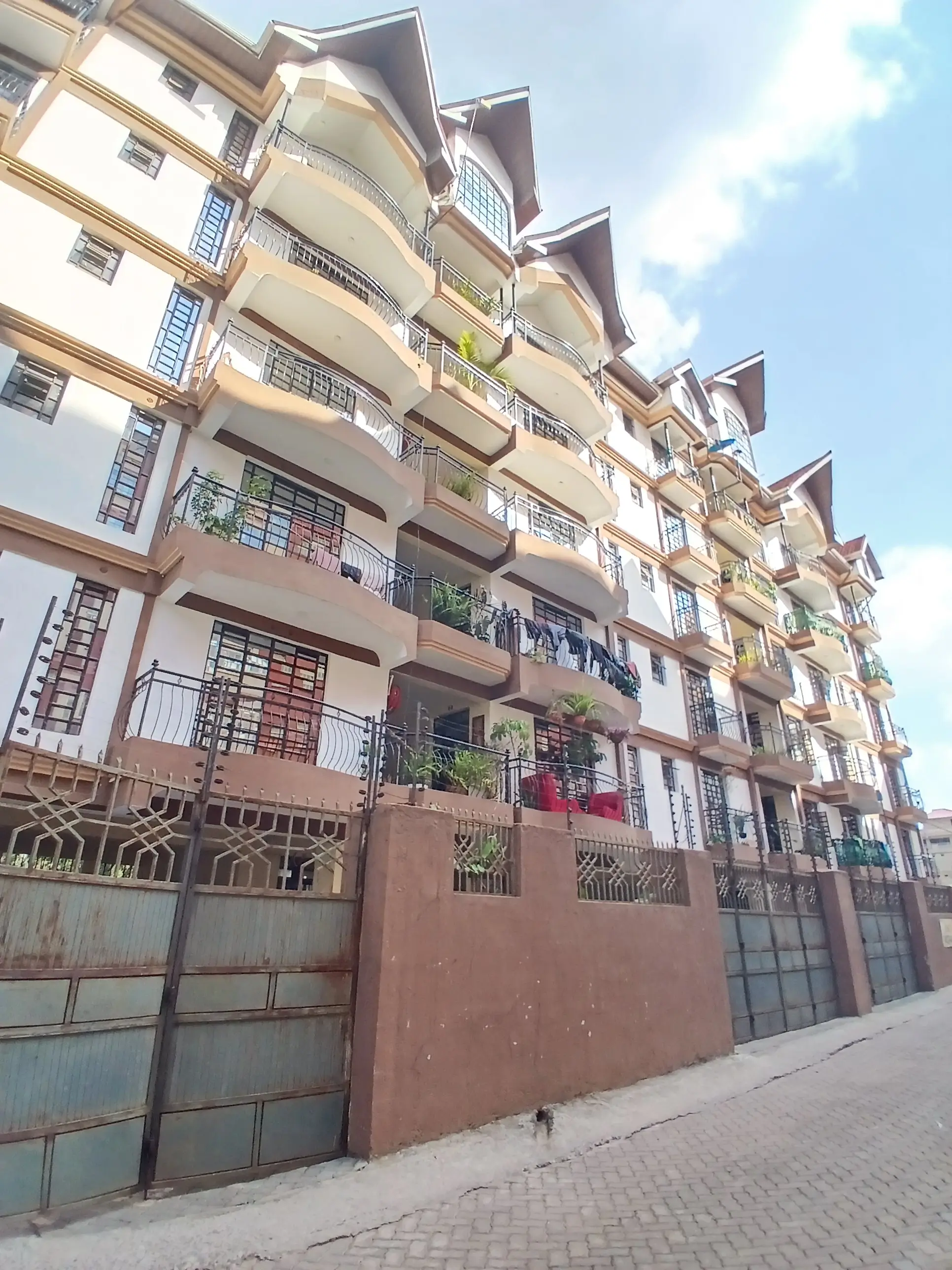 Multi-story residential building facade with balconies and parking gate
