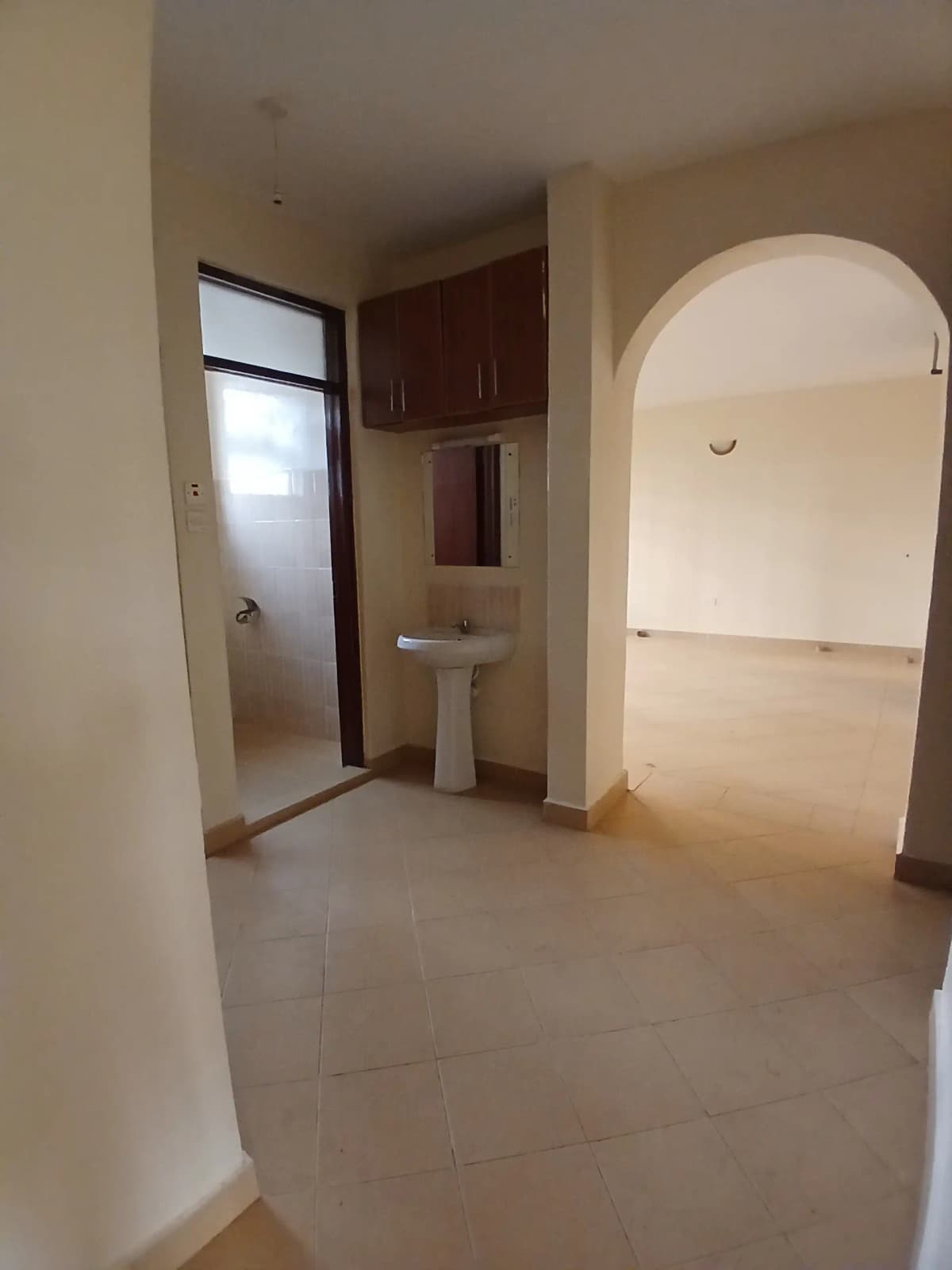 Bright corridor with archway entrance and pedestal sink