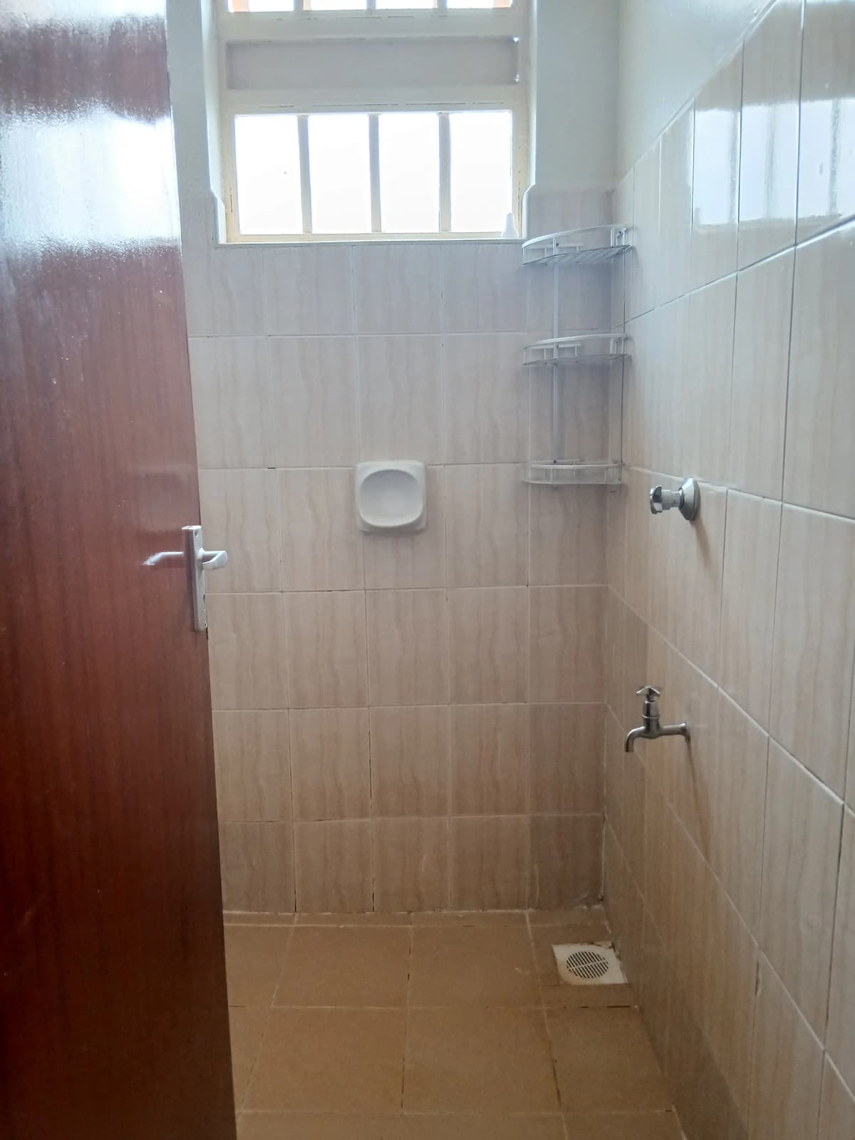 Simple bathroom with tiled walls and basic shower setup