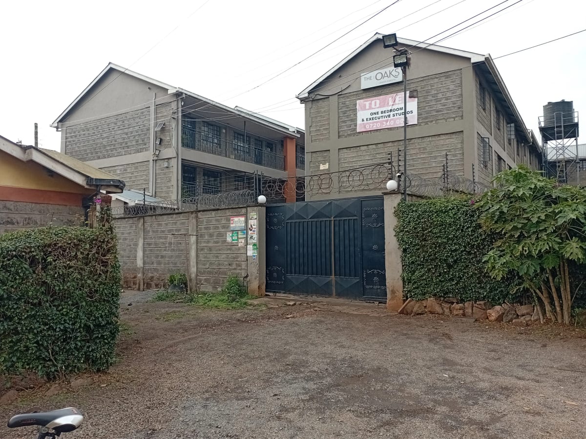 Multi-story residential building with gated entrance and compound