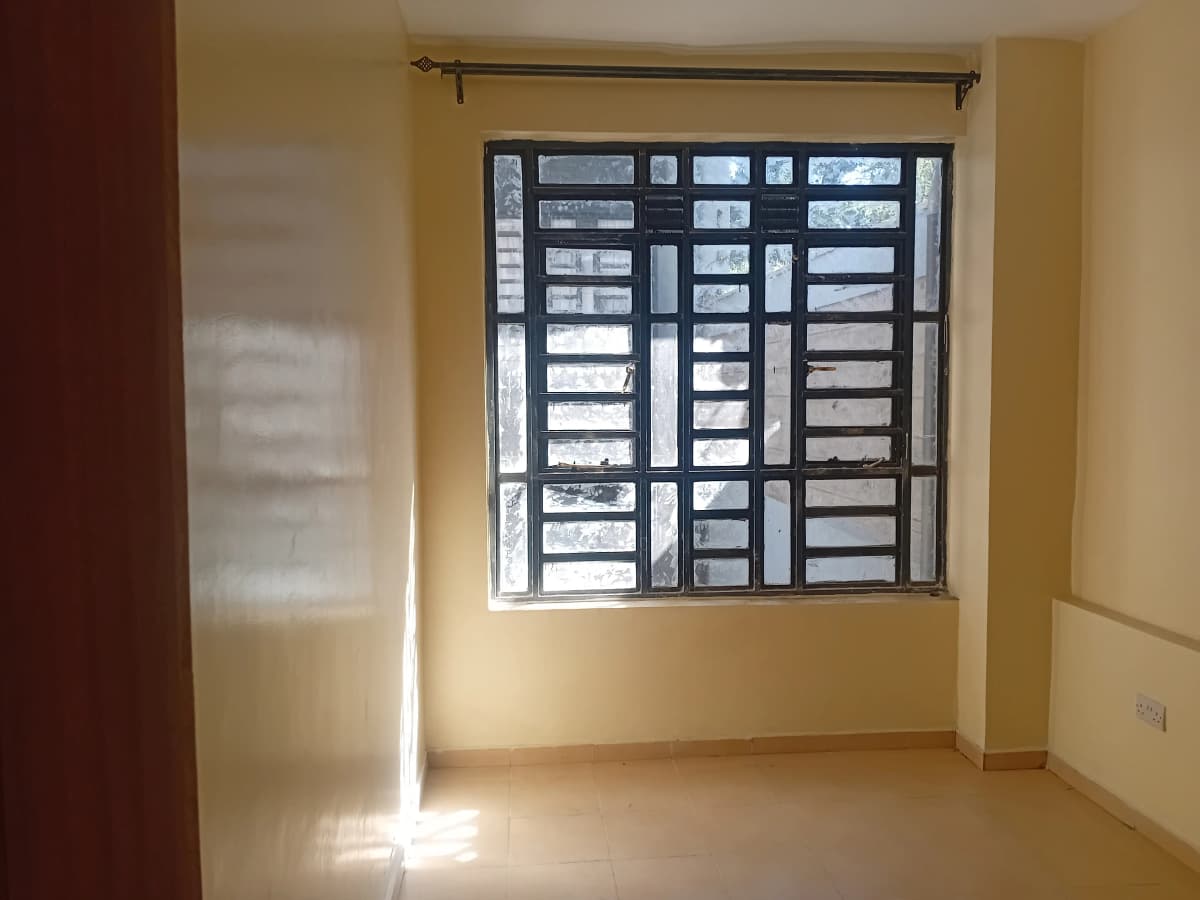 Bright bedroom with barred window and neutral walls