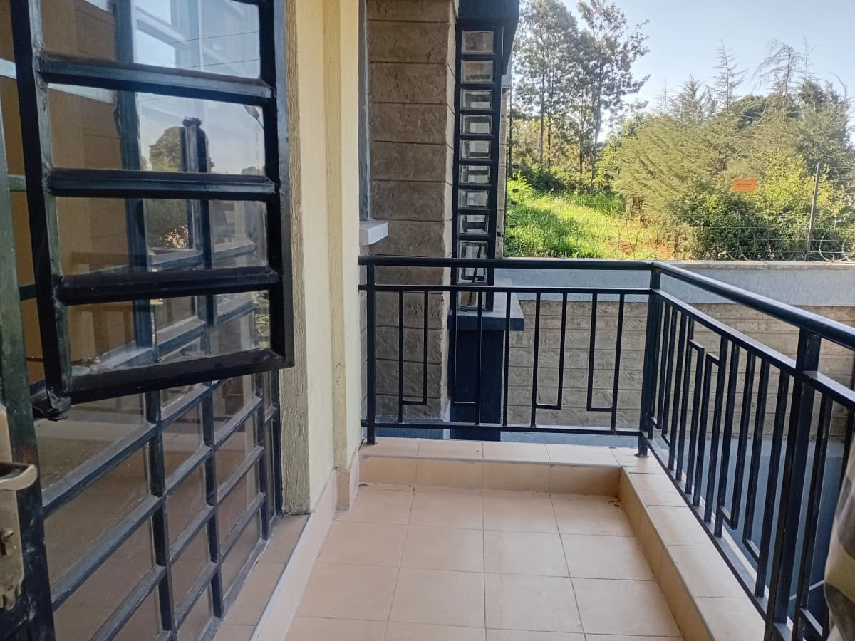 Spacious balcony with black railing and garden views