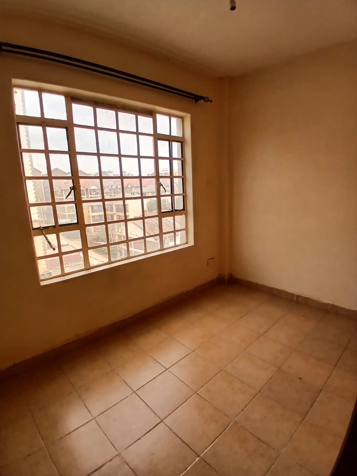 Unfurnished bedroom with terracotta tiles and large window