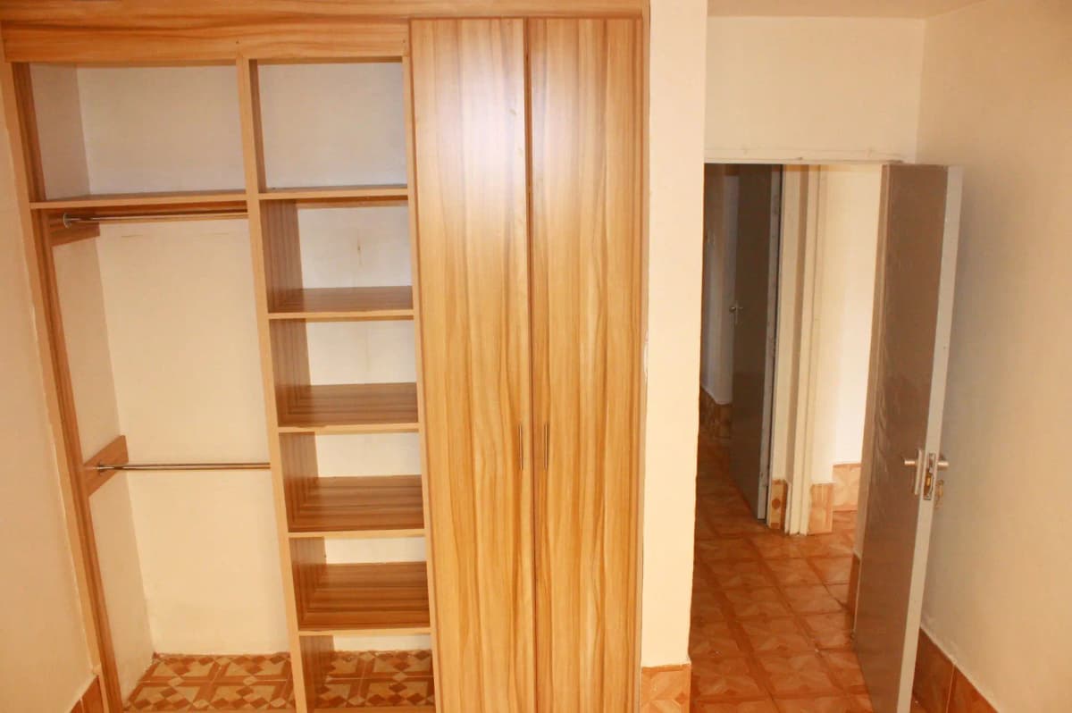 Bedroom with built-in wooden wardrobes and parquet flooring