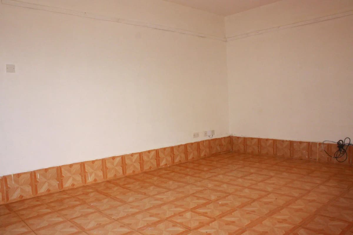 Empty room with terracotta tile flooring and white walls