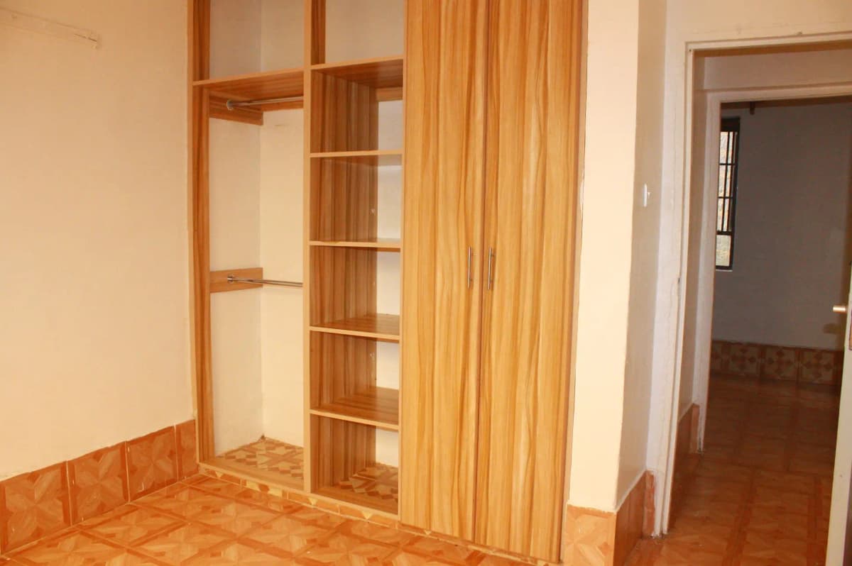 Bedroom with wooden built-in wardrobe and curtains