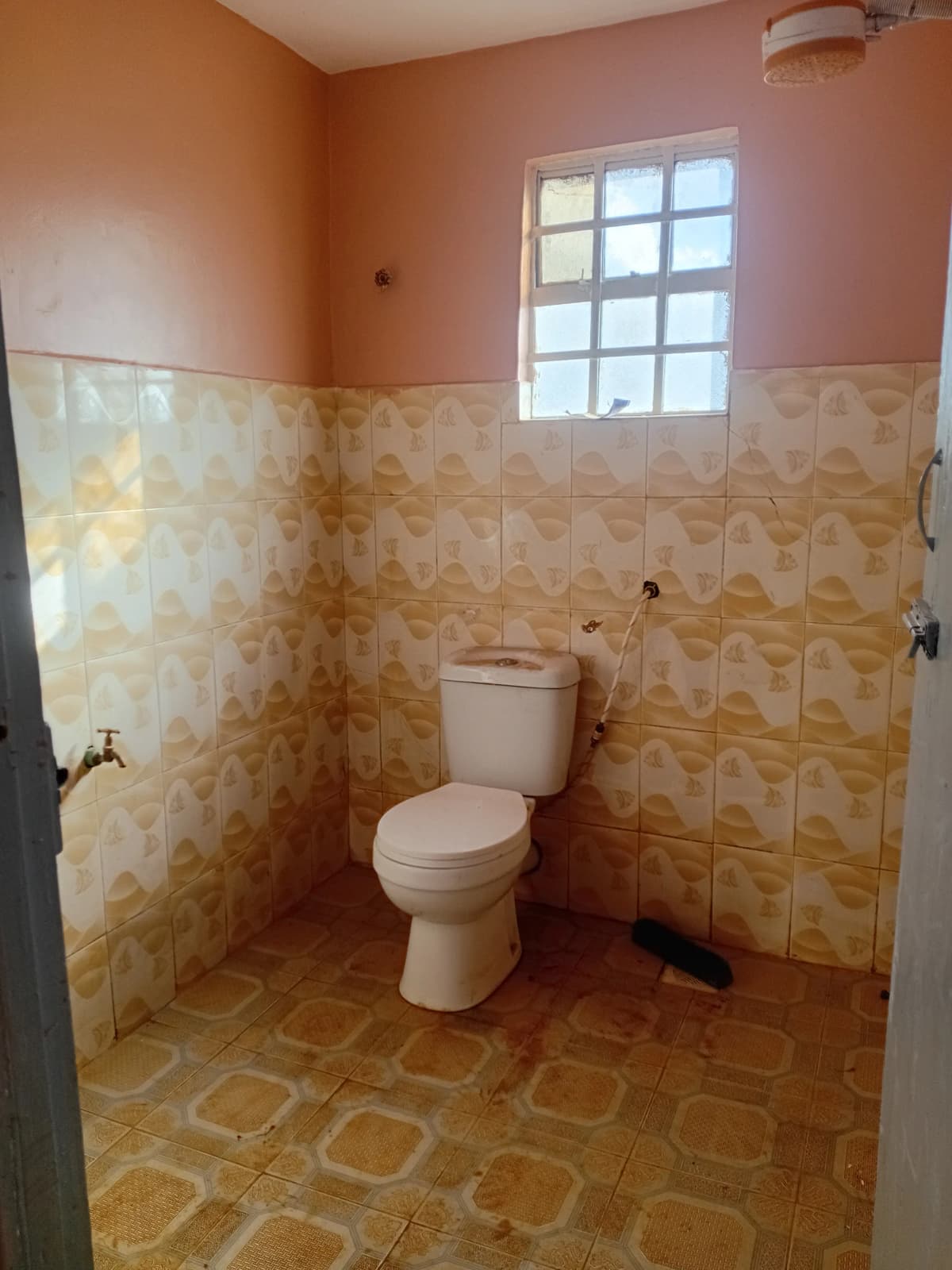 Basic bathroom with toilet, ceramic tile walls and floor
