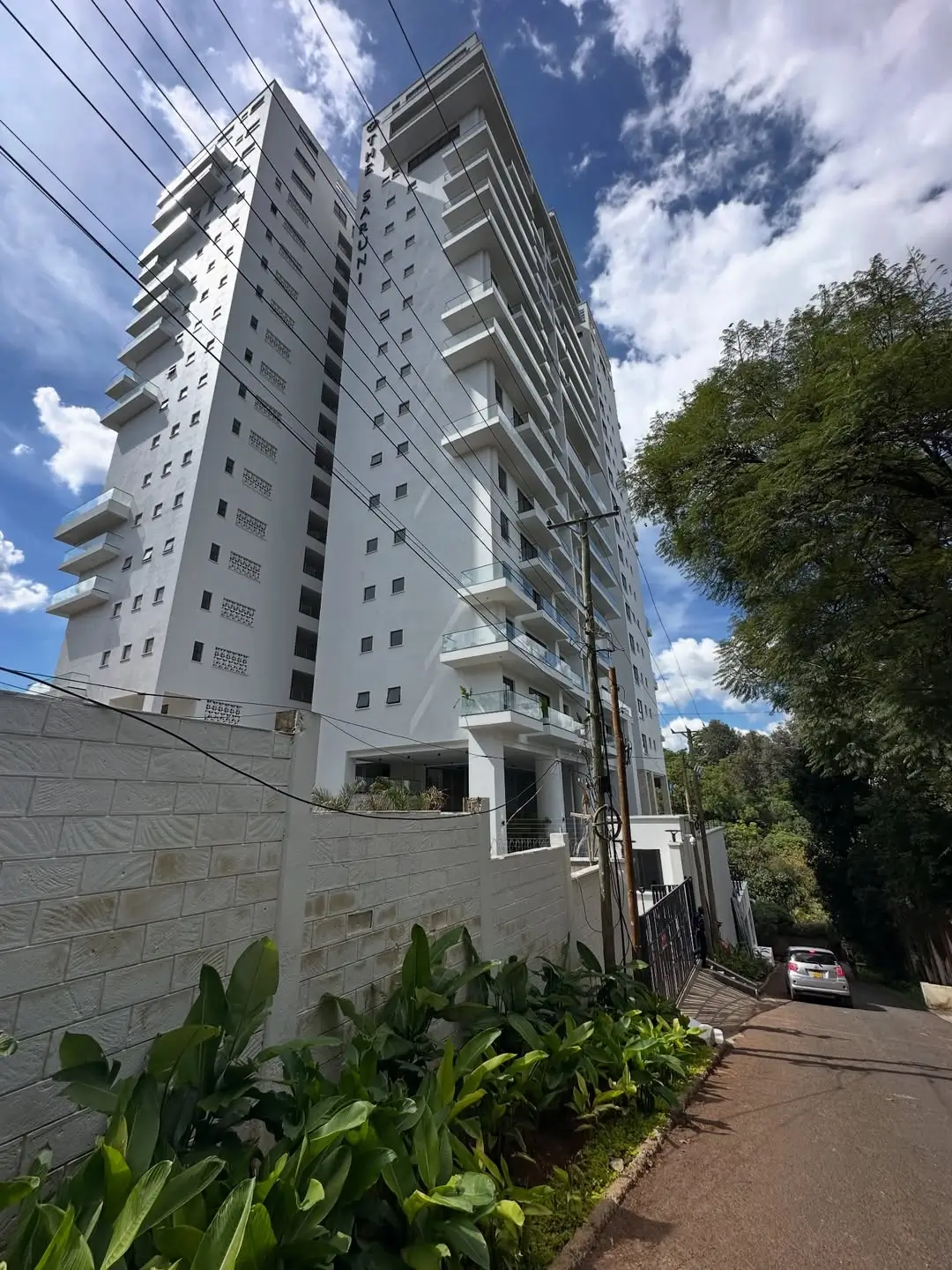 Modern multi-story residential building with white facade and balconies