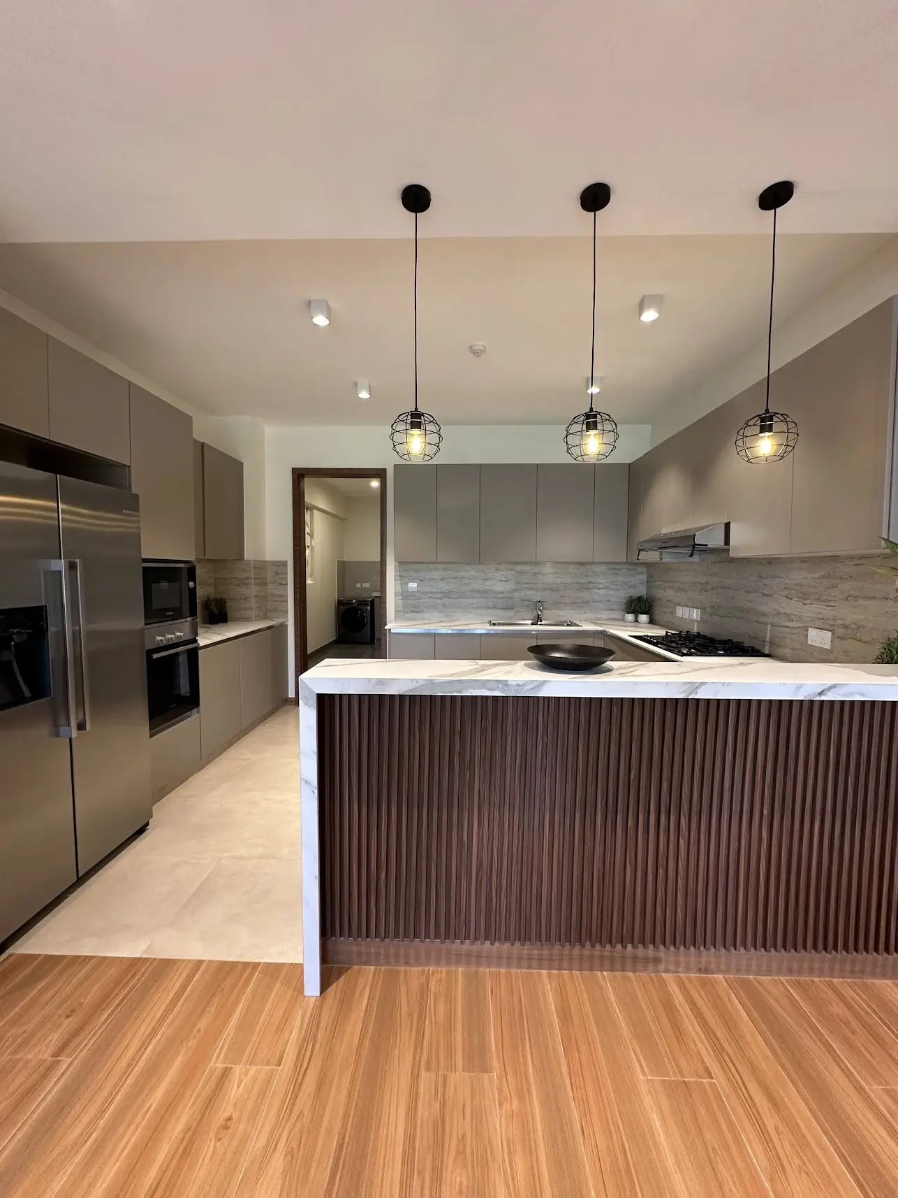 Modern kitchen with island, pendant lights, marble countertop