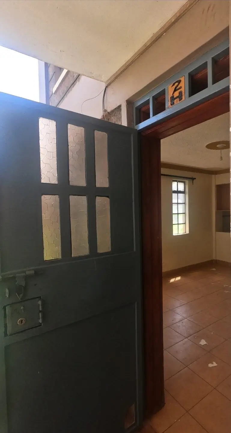 Hallway entrance with black paneled door and tile flooring