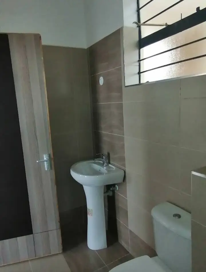 Compact bathroom with pedestal sink and toilet fixture