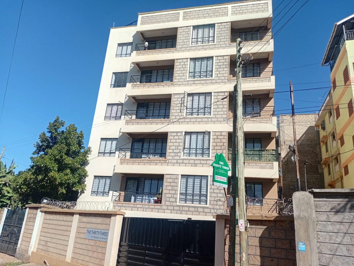 Multi-story residential building facade with balconies and ground-level garage