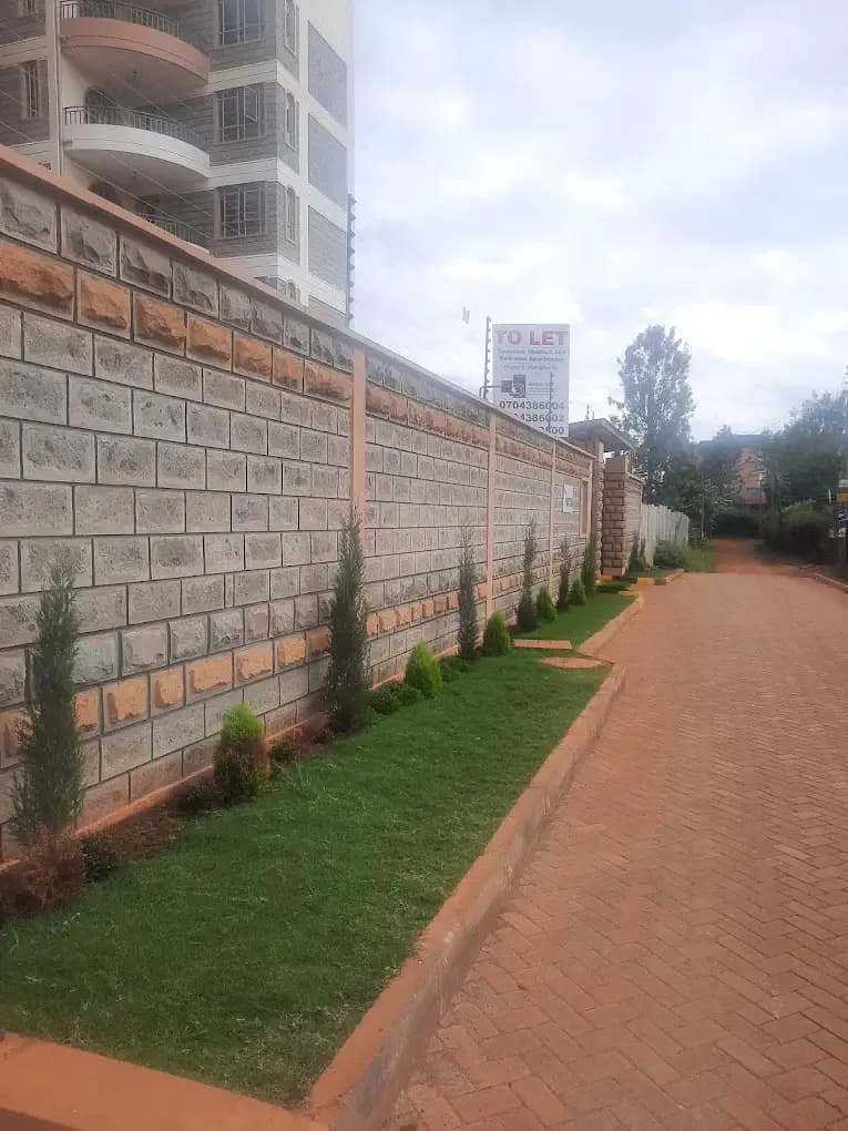Compound perimeter wall with landscaped grounds and brick paving