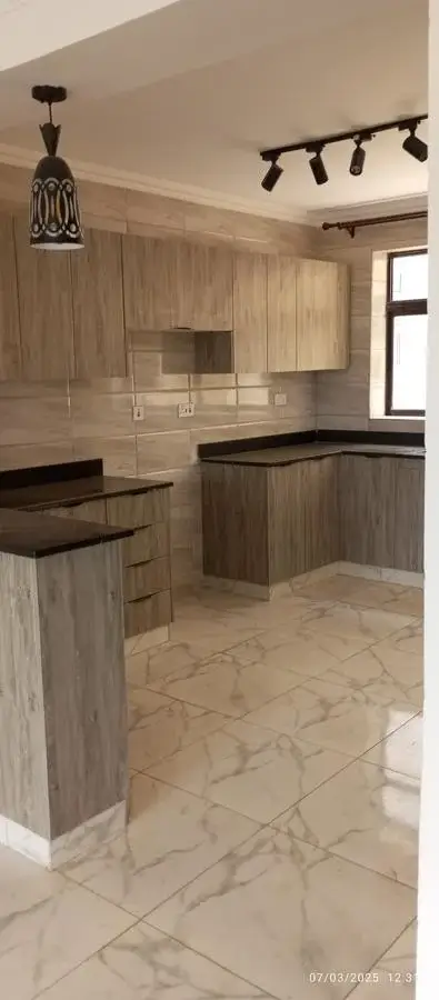 Modern kitchen with light wood cabinetry and marble flooring