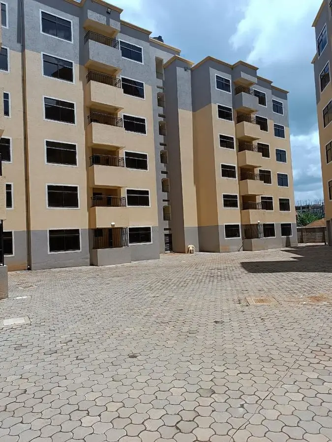 Modern multi-story residential building with paved courtyard