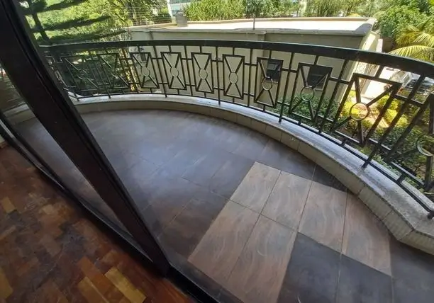 Curved balcony with geometric railing and garden views