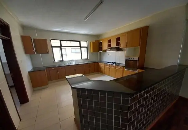 Spacious kitchen with wooden cabinets and black island counter
