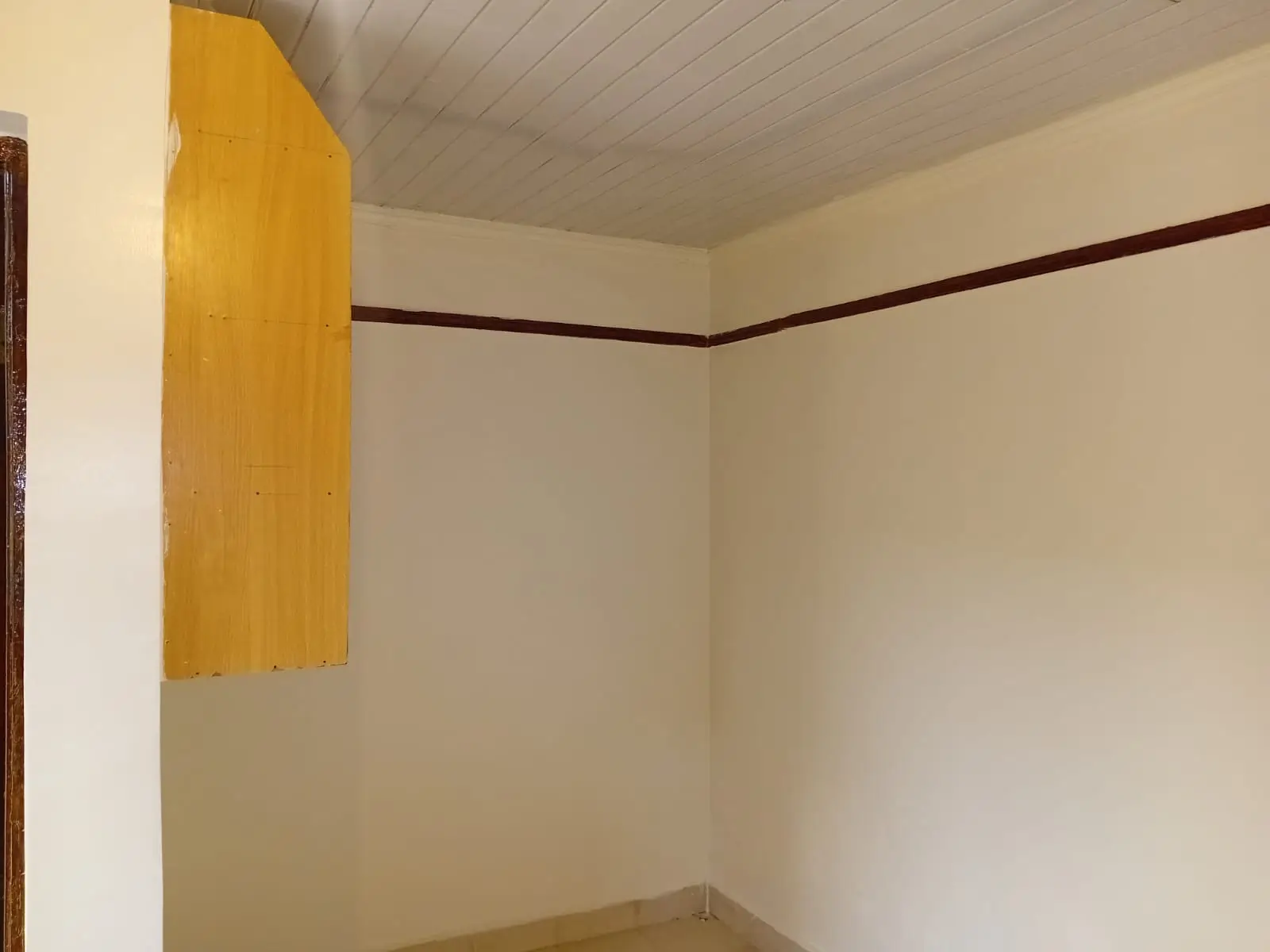 Compact bedroom with cream walls and dark trim accents