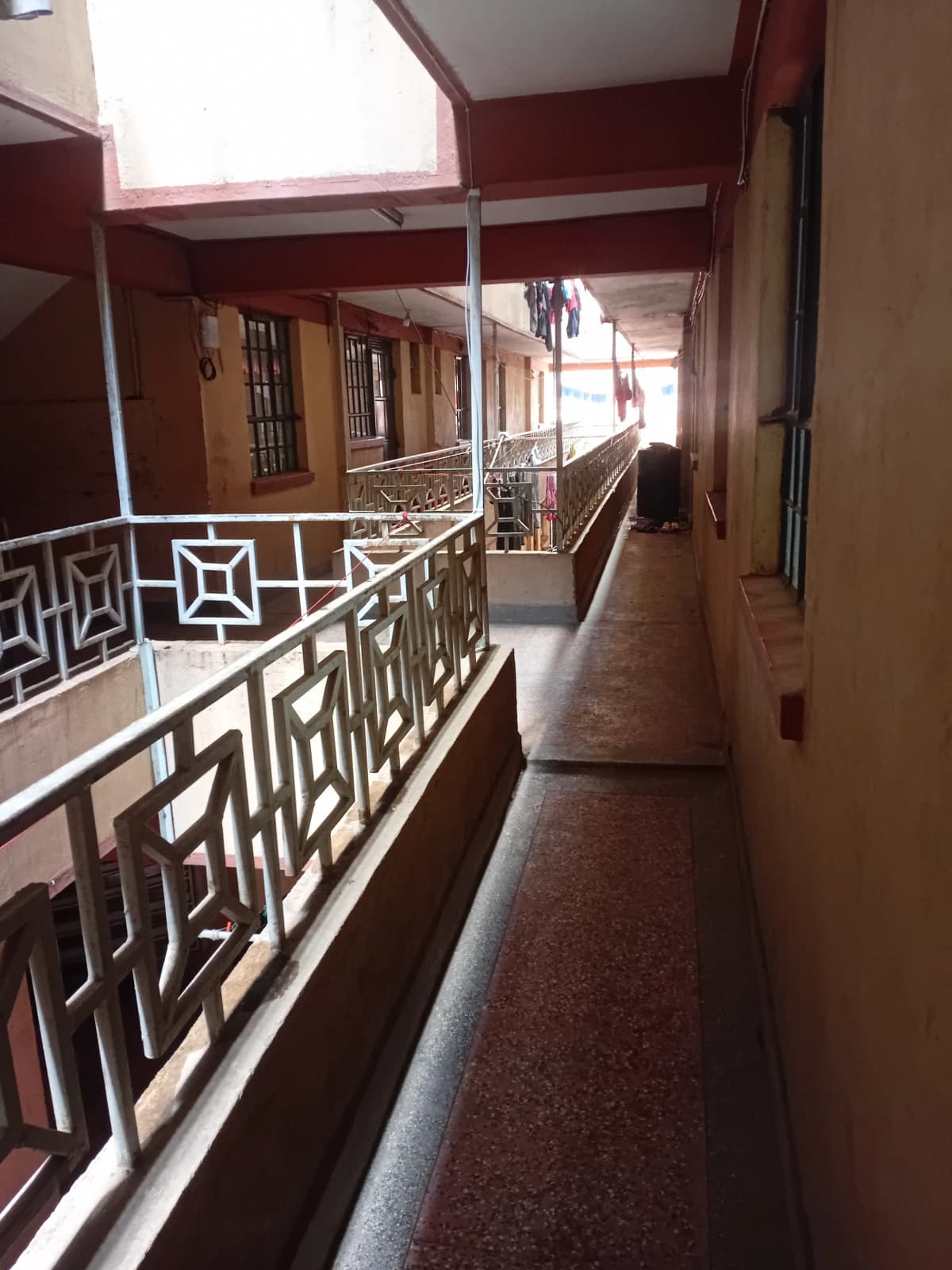 Long covered balcony with geometric railings and corridor access