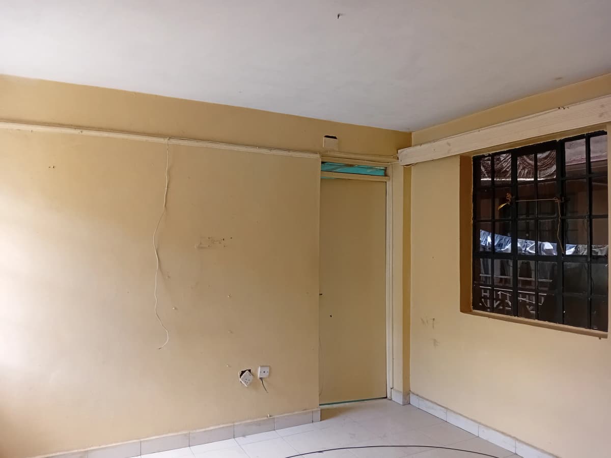 Empty bedroom with yellow walls and dark window frame