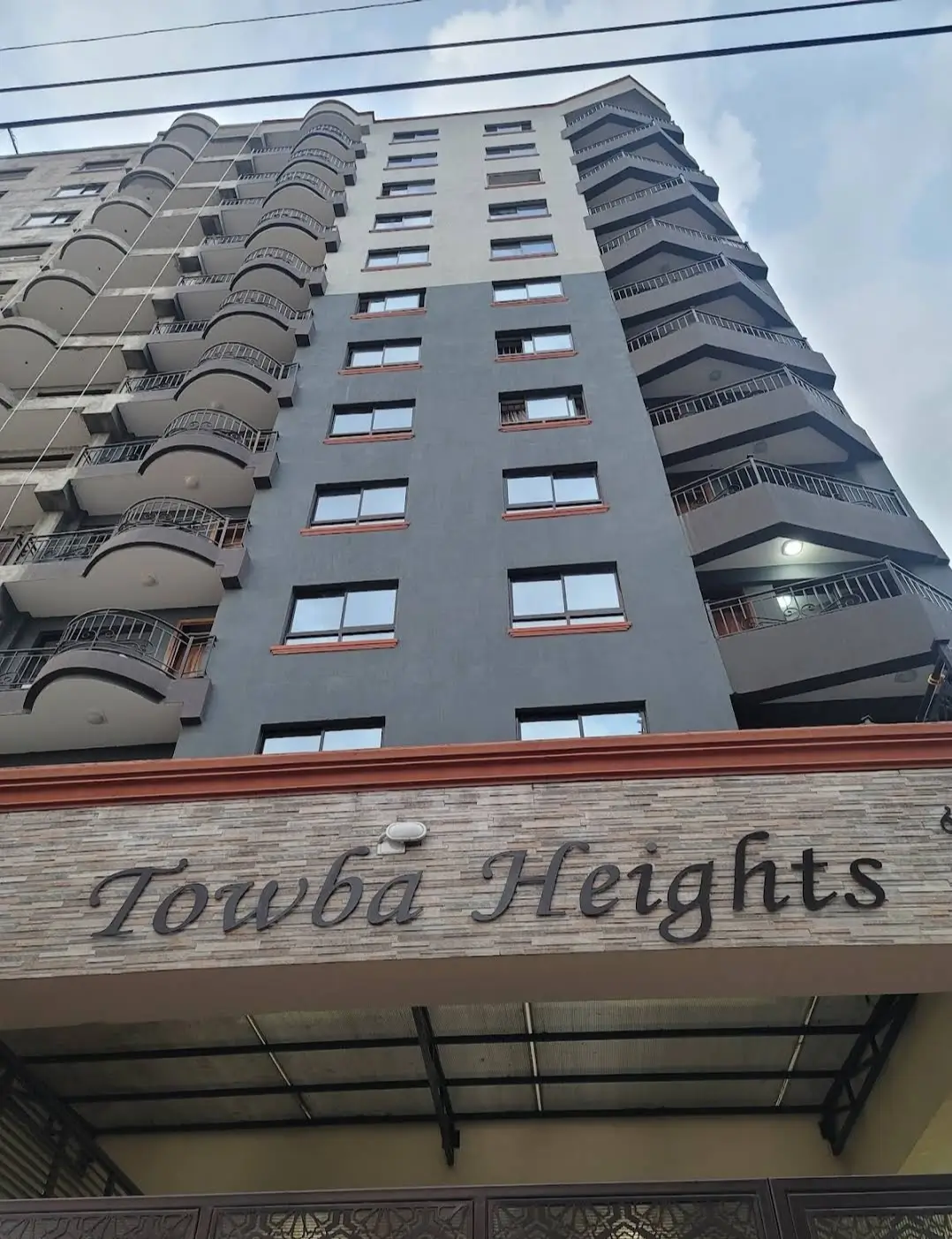 Modern multi-story residential building facade with curved balconies
