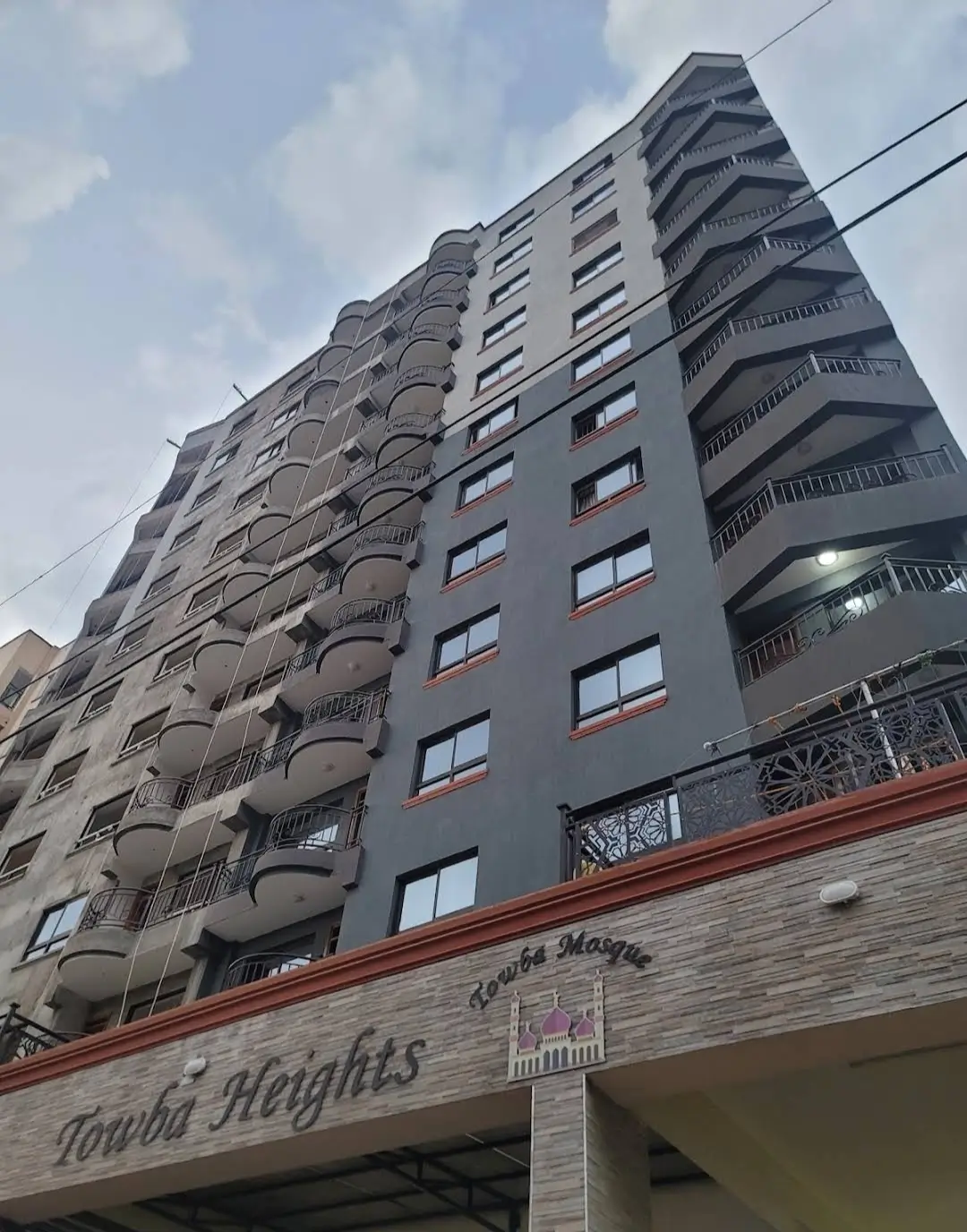 Multi-story residential building facade with balconies and ground-level entrance