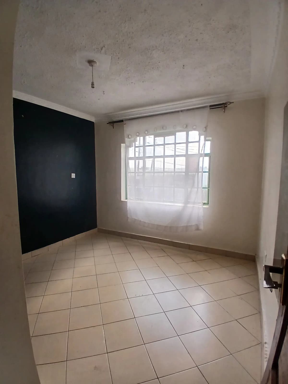 Bright bedroom with tiled floor and barred window