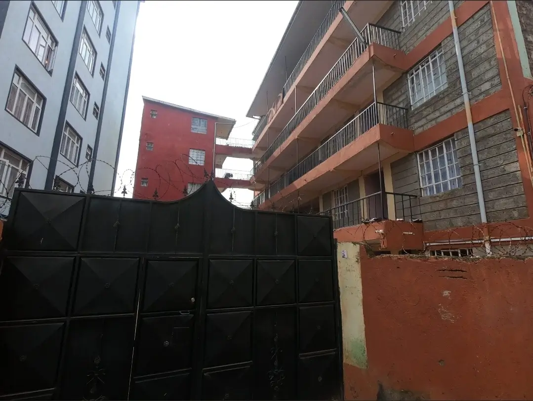 Multi-story residential building with black metal gate entrance