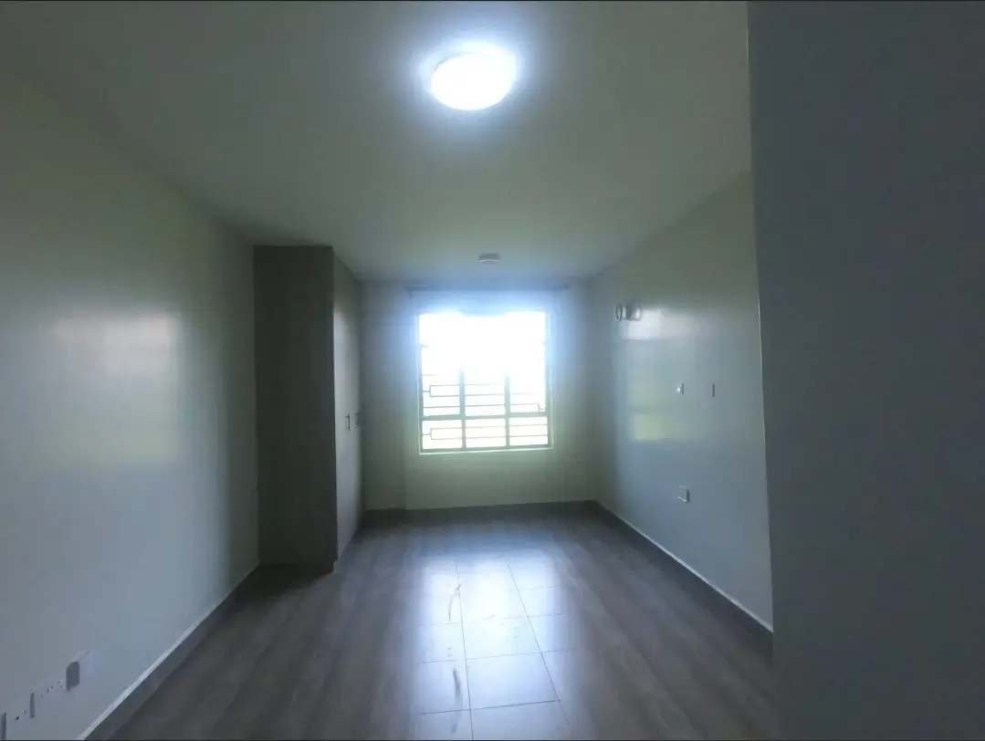 Spacious empty bedroom with natural light from window