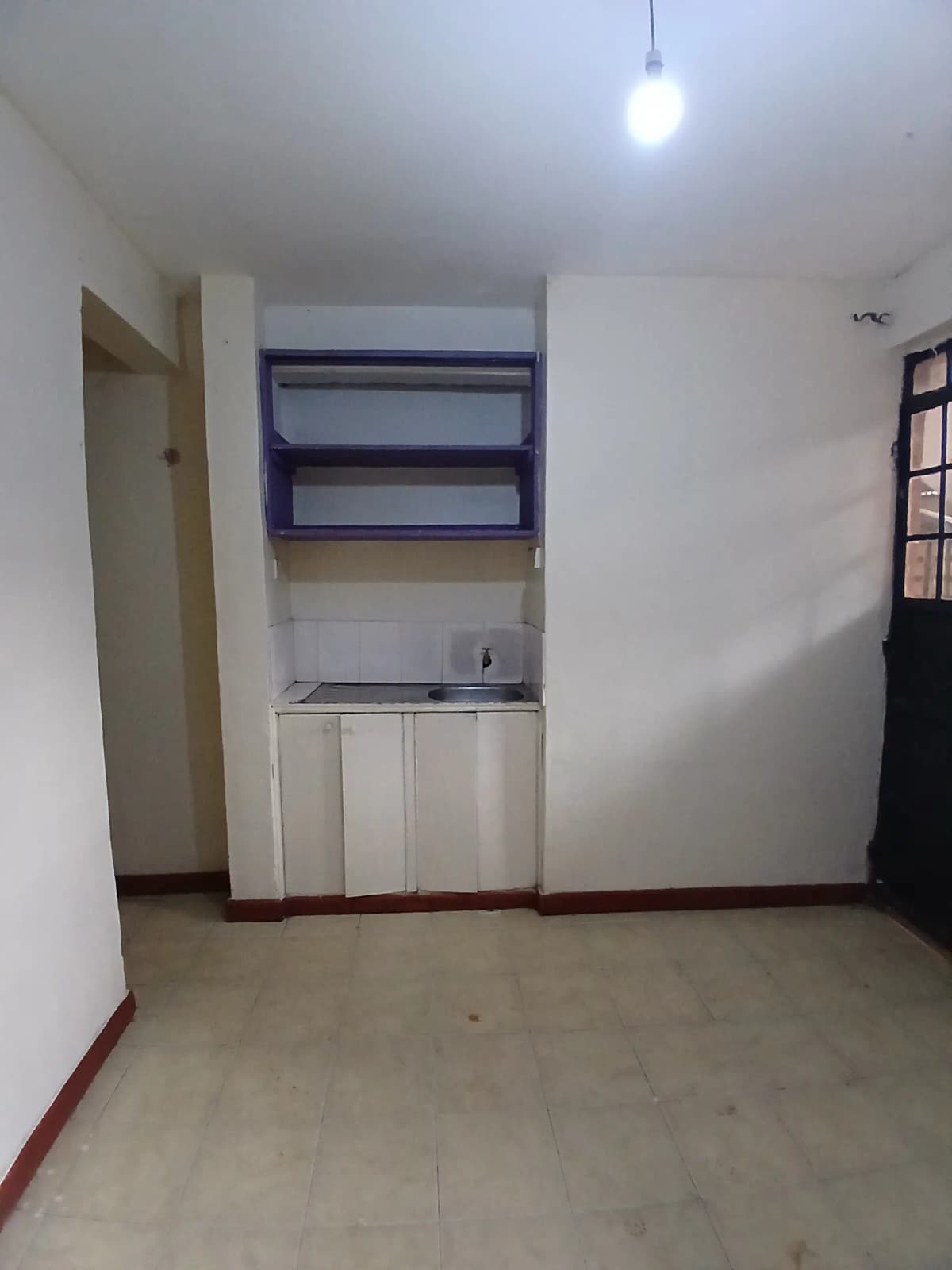 Compact kitchen with white cabinets and blue wall shelving