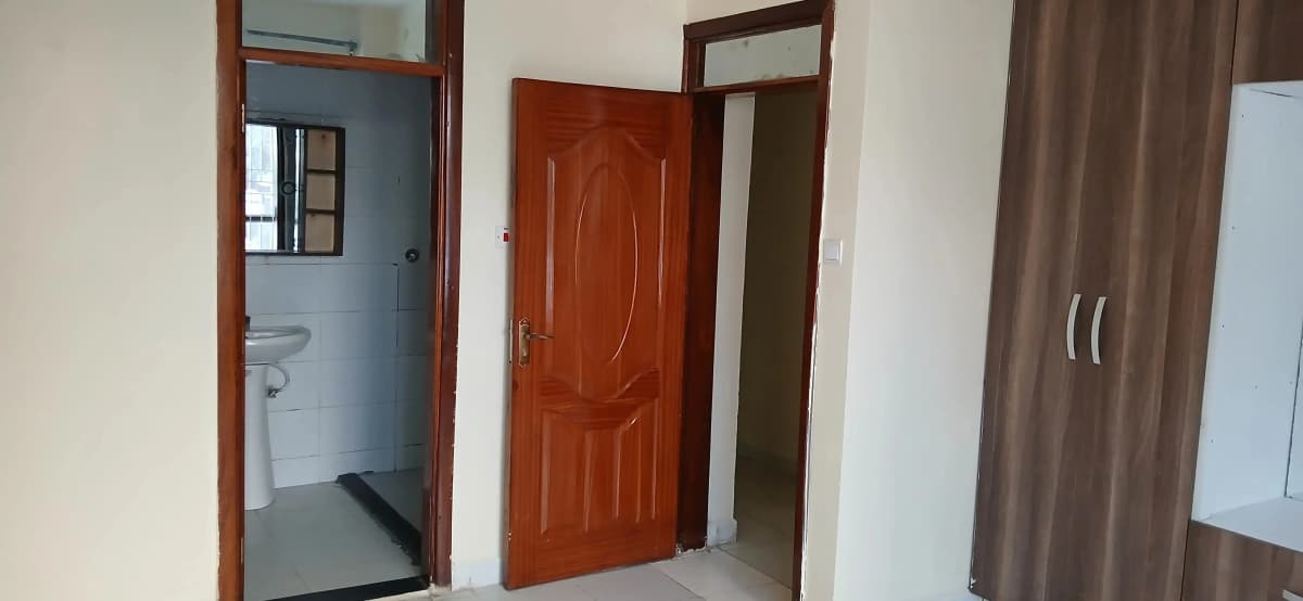 Hallway with bathroom entry and wooden doors