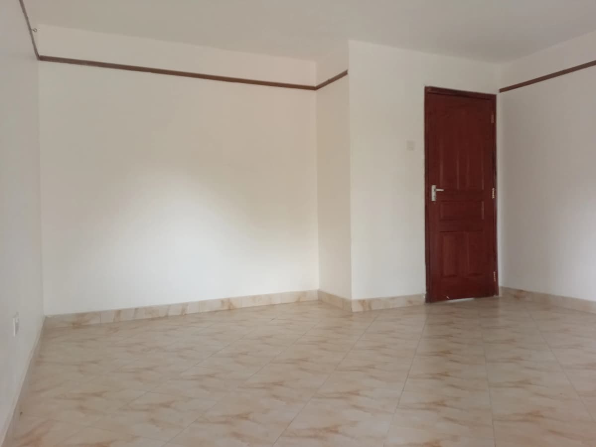 Empty living room with wooden floor and burgundy door