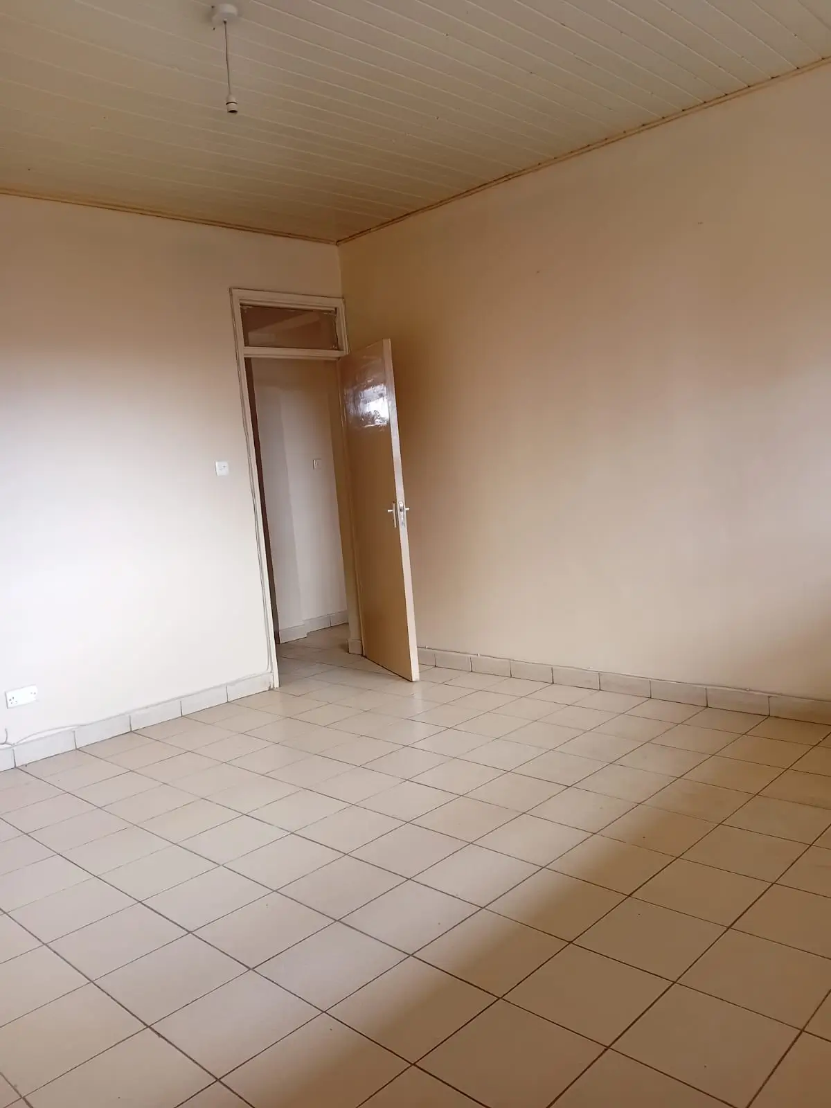 Empty bedroom with tiled floor and open door
