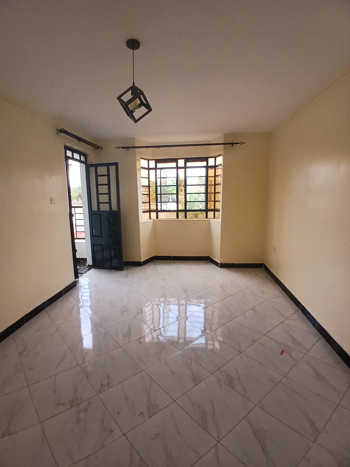 Empty living room with polished tile floor and natural light