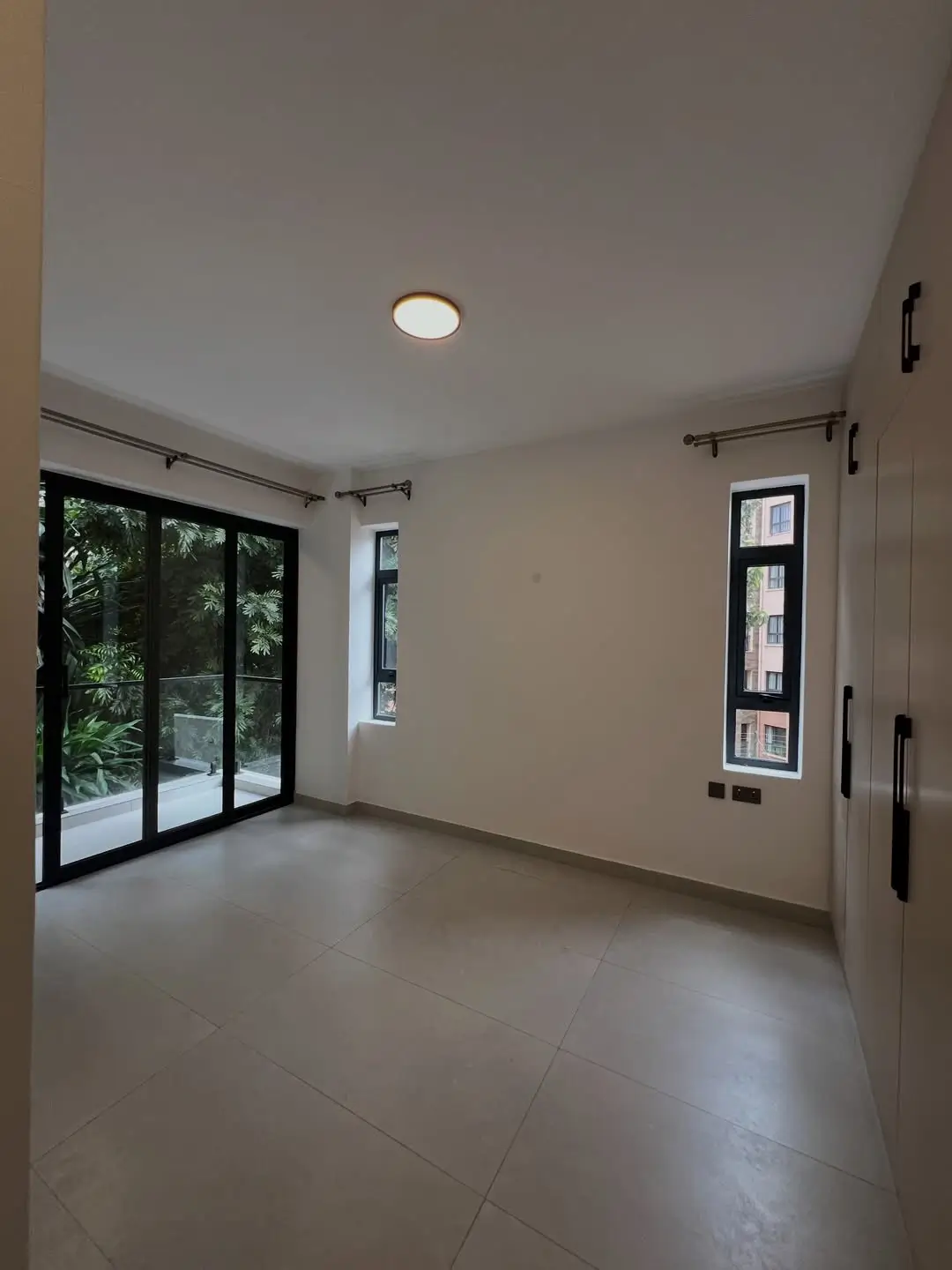 Empty bedroom with glass sliding doors and natural light