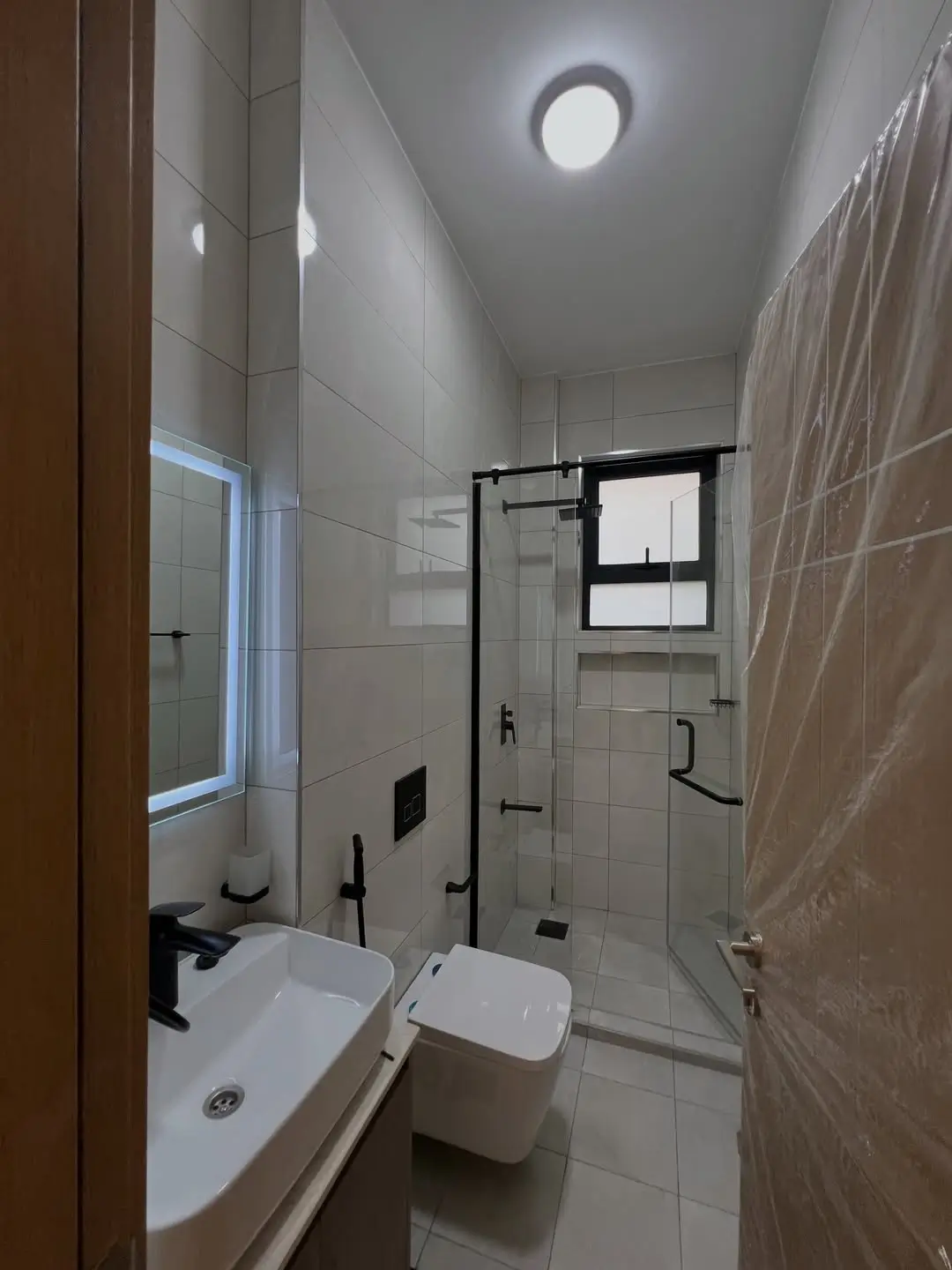 Modern bathroom with sink, toilet, glass shower enclosure