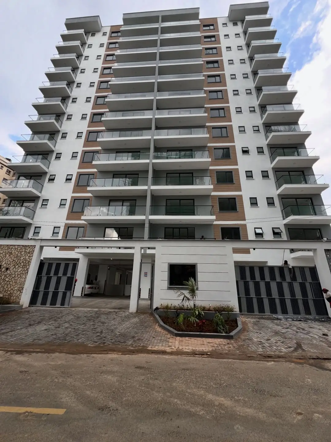 Modern multi-story residential building with ground-level parking.
