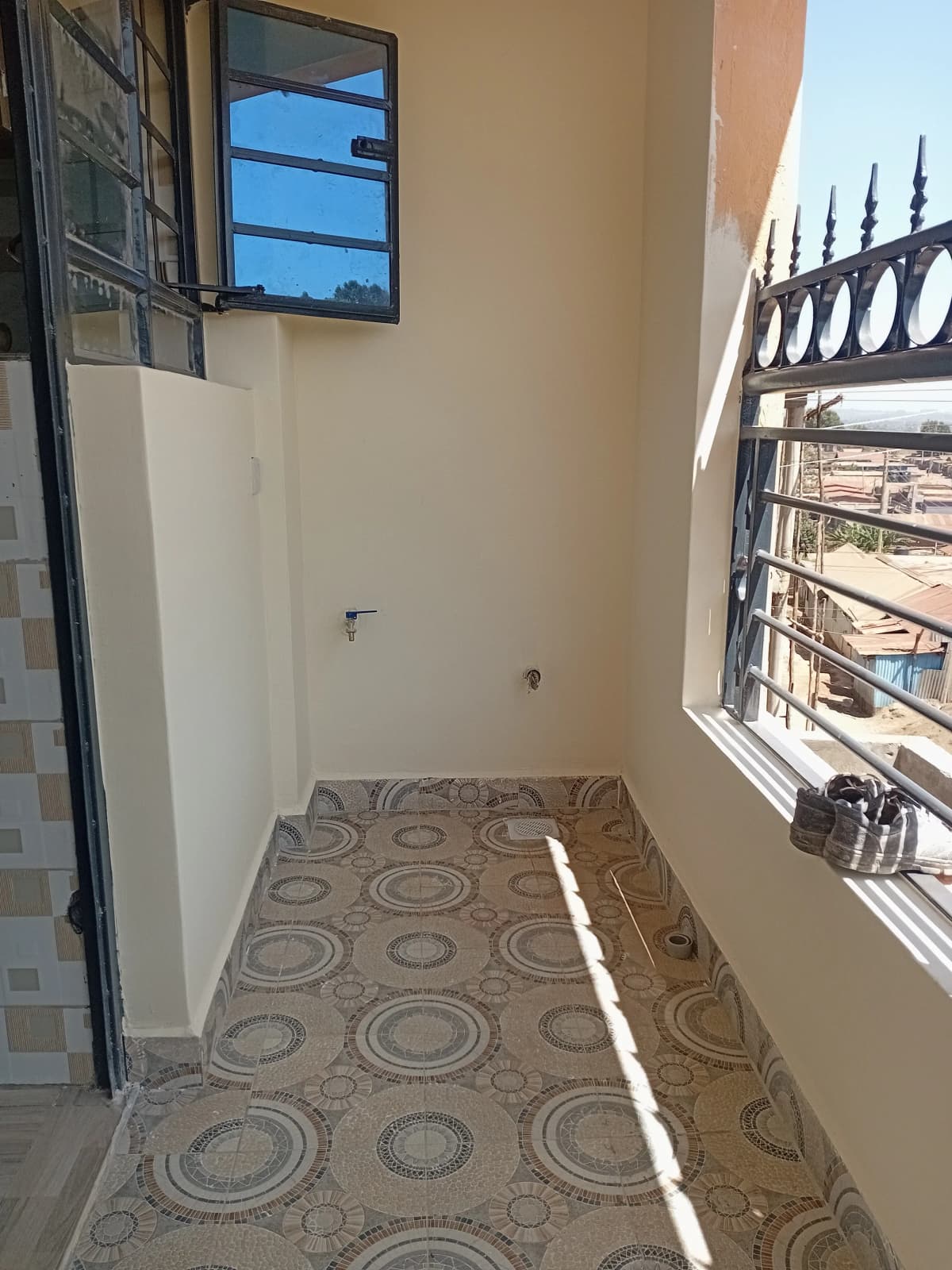 Narrow balcony with patterned flooring and metal railing