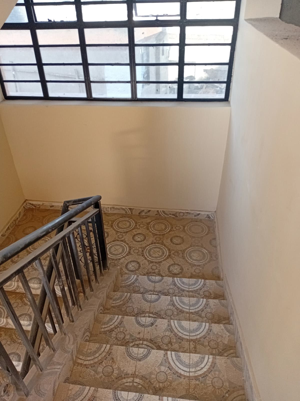 Interior stairwell with patterned tiles and metal railings