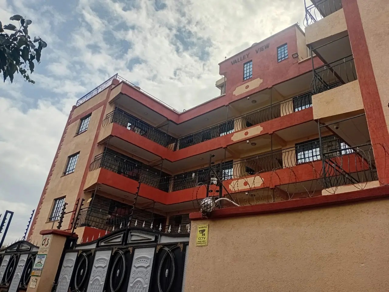 Multi-story residential building with red and cream facade