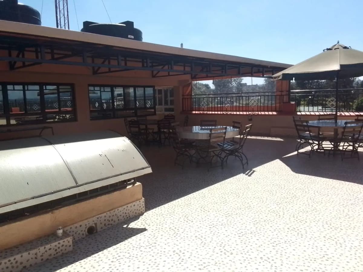 Rooftop terrace with seating and railing overlooking grounds