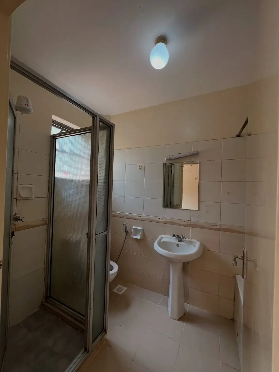 Clean bathroom with pedestal sink and enclosed shower cubicle