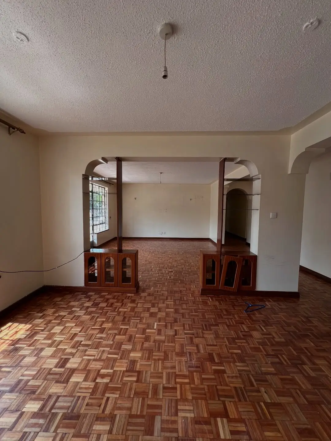 Spacious living room with parquet flooring and arched doorways
