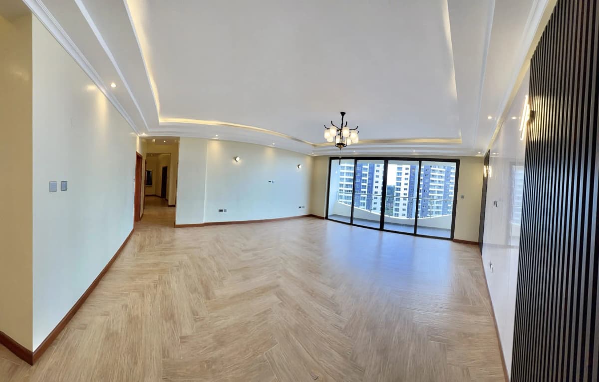Spacious open-plan living area with herringbone flooring and city views